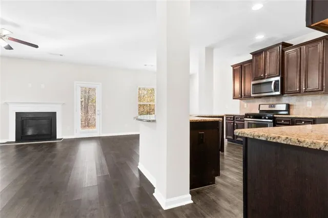 a kitchen with stainless steel appliances granite countertop a stove top oven a sink and a microwave