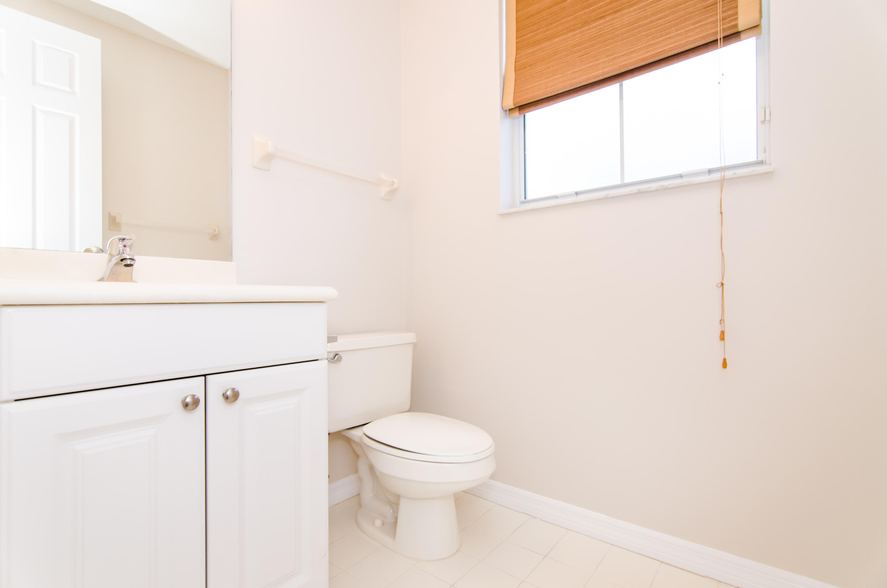4281 East Main Street Jupiter, FL 33458 - Photo 22 of 37 a white toilet sitting next to a bathroom sink