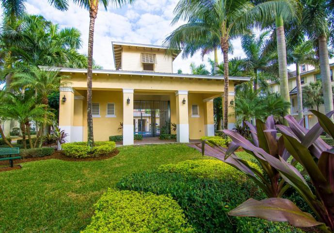 4281 East Main Street Jupiter, FL 33458 - Photo 36 of 37 a view of a white house with a big yard and potted plants and palm trees