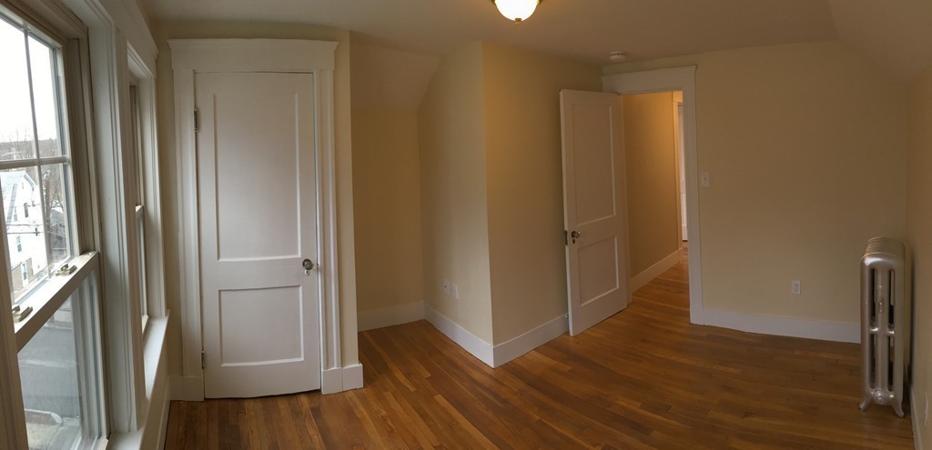 22 Sutherland Road Arlington, MA 02476 - Photo 29 of 30 an empty room with wooden floor and a window