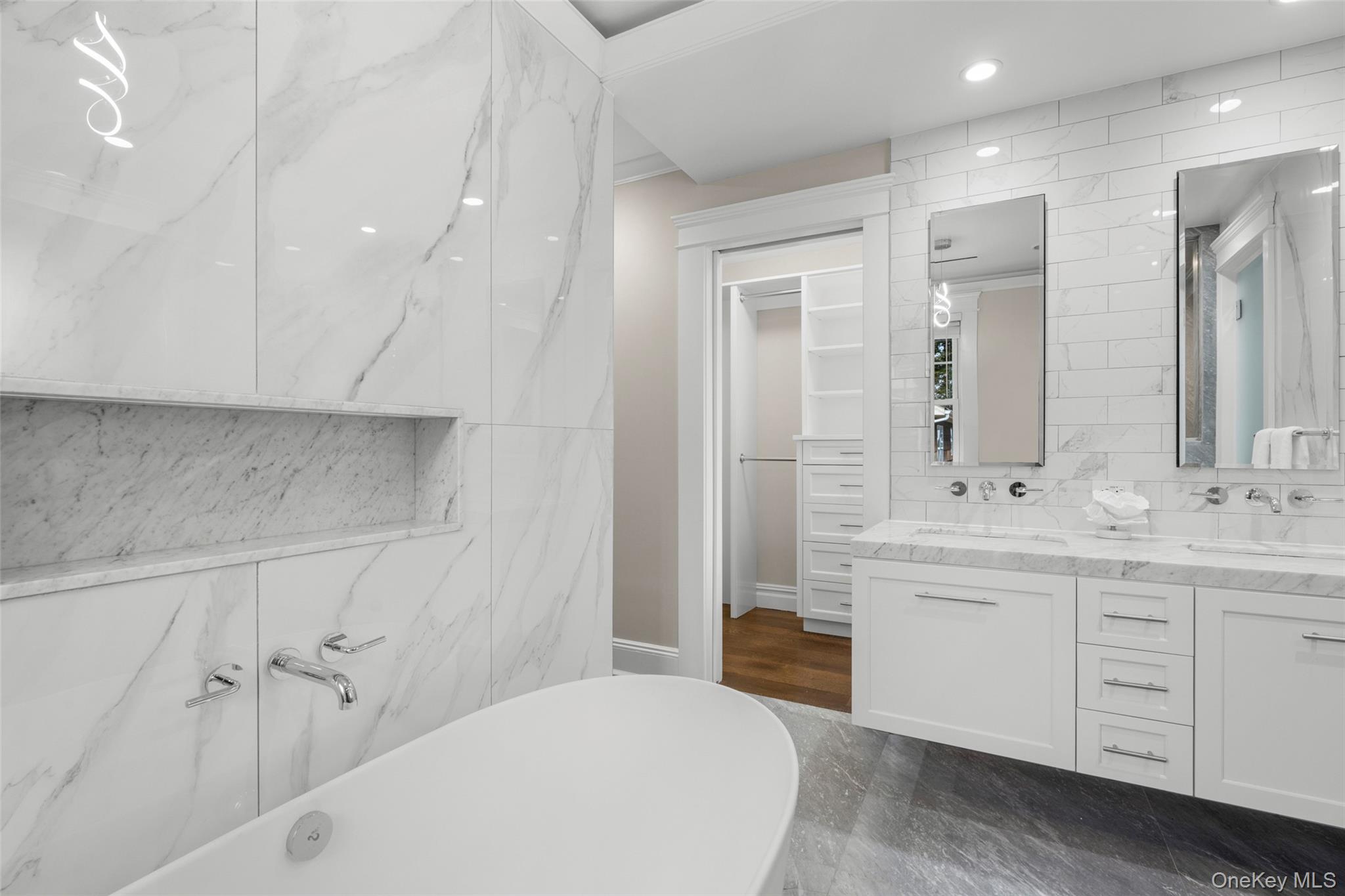 69 Irving Place New Rochelle, NY 10801 - Photo 21 of 46 a bathroom with a double vanity sink a mirror and a bathtub