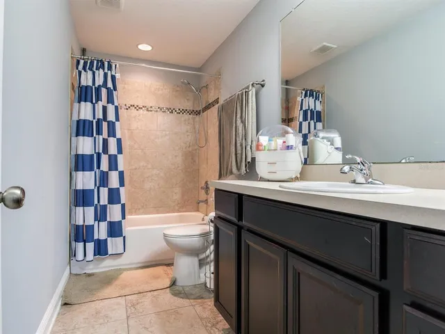 a spacious bedroom with a bed and a chandelier