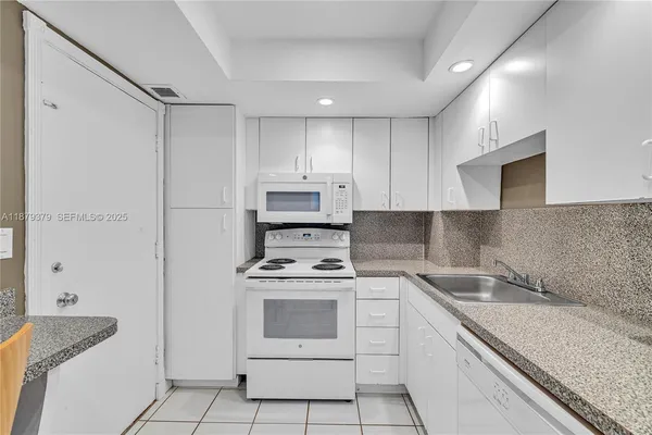 a kitchen with a stove sink and cabinets