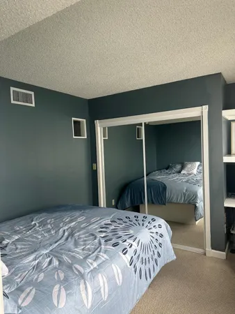 a bedroom with a bed and a large window