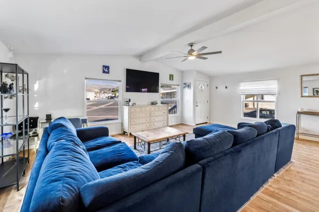 a living room with furniture ceiling fan and a flat screen tv