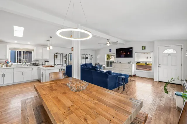 a large white kitchen with cabinets and wooden floor