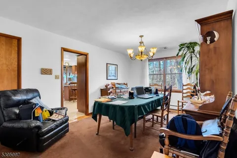 a living room with furniture a chandelier and a dining table
