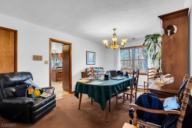 a living room with furniture a chandelier and a dining table