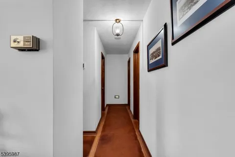 a view of a hallway with wooden floor and stairs