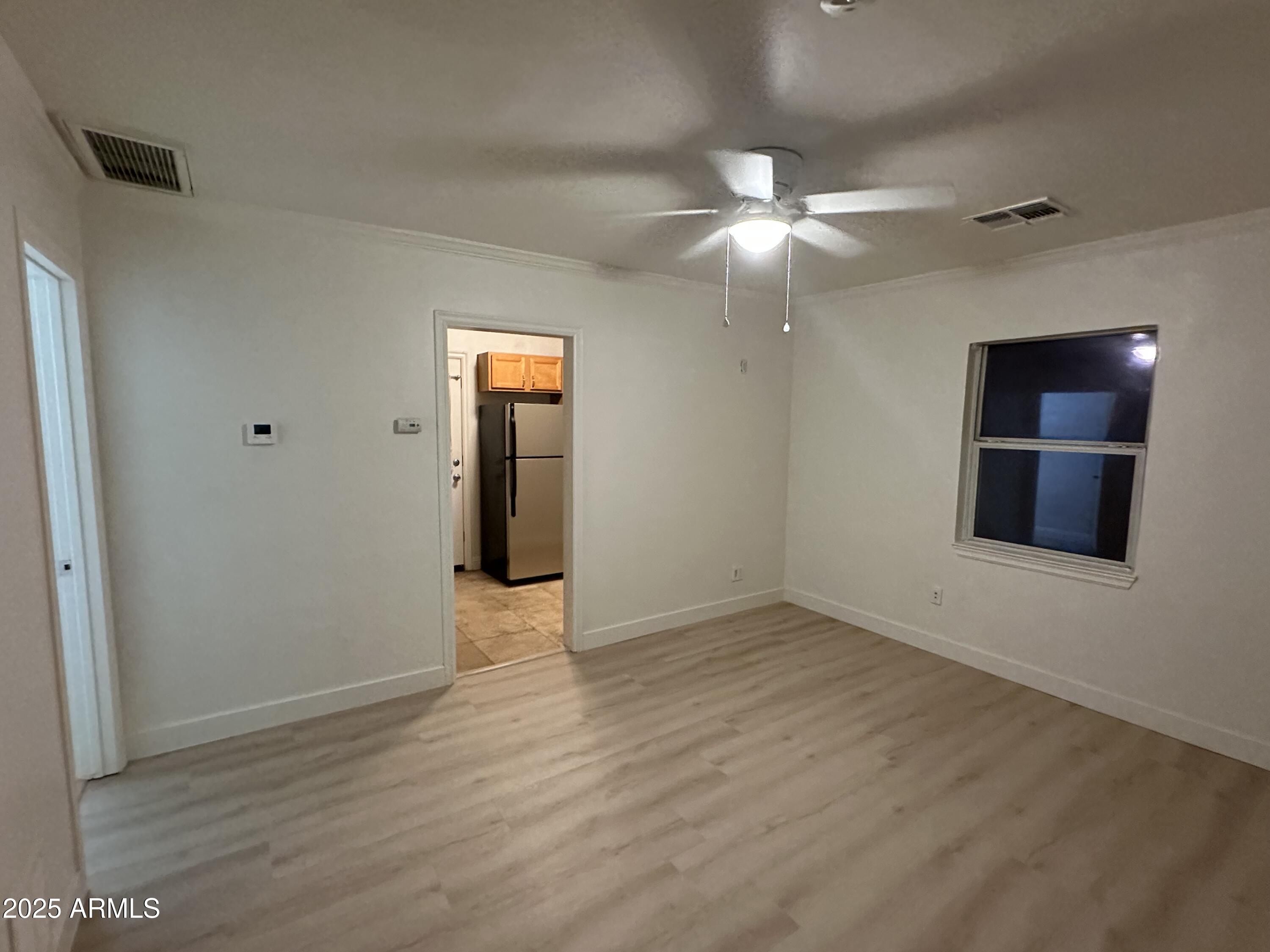 636 North 4th Avenue, Unit 3 Phoenix, AZ 85003 - Photo 4 of 8 a view of an empty room with window and wooden floor