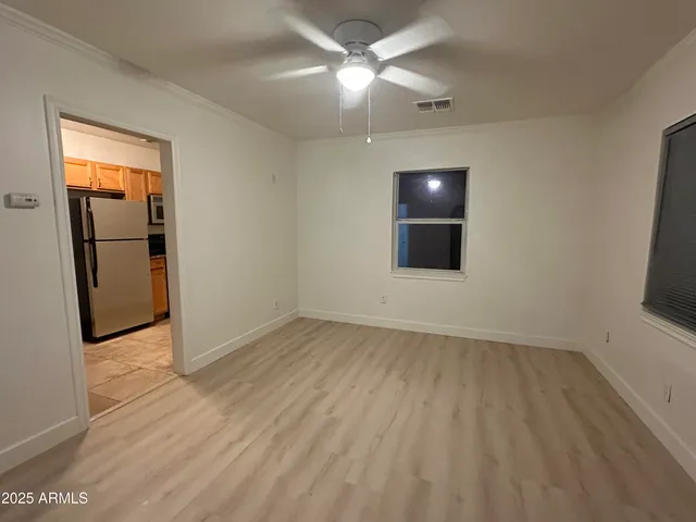 an empty room with wooden floor and mirror