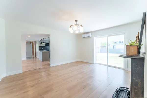 a view of a room with wooden floor and kitchen