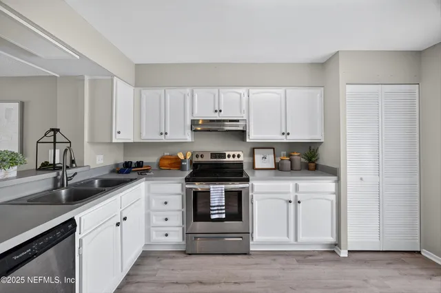a kitchen with white cabinets and stainless steel appliances