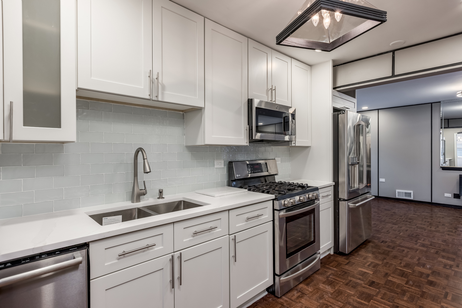 9539 Lorel Avenue Skokie, IL 60077 - Photo 10 of 38 a kitchen with stainless steel appliances granite countertop grey cabinets a stove a refrigerator and a sink