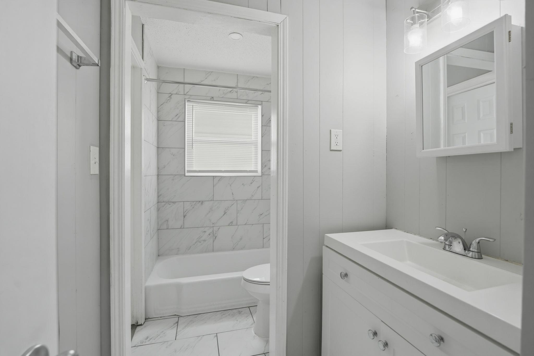 4686 Gill Road Memphis, TN 38109 - Photo 27 of 32 Bathroom featuring a white vanity with integrated sink, chrome faucet, and clear knob hardware