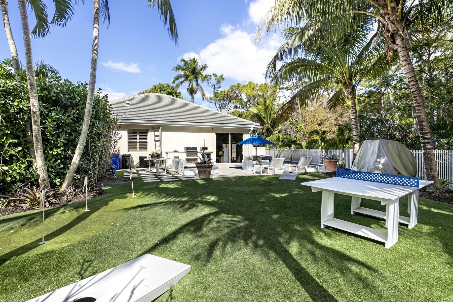 5226 Southeast Inkwood Way Hobe Sound, FL 33455 - Photo 22 of 30 a view of a patio with table and chairs potted plants and large tree