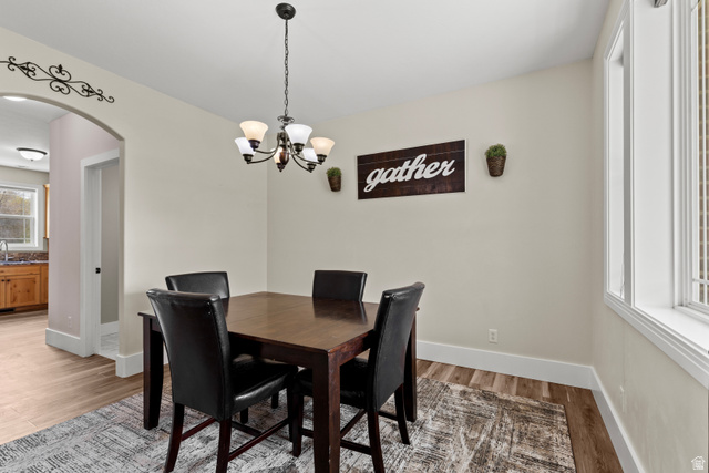 75 East 200 North Mendon, UT 84325 - Photo 7 of 36 Dining space featuring arched walkways, a chandelier, and light wood-style flooring