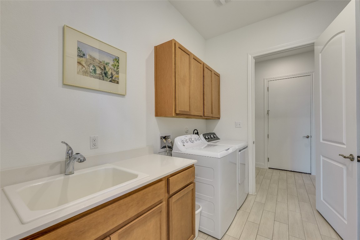 616 Climbing Rock Loop Dripping Springs, TX 78620 - Photo 18 of 35 Washroom with separate washer and dryer, cabinet space, and wood finish floors