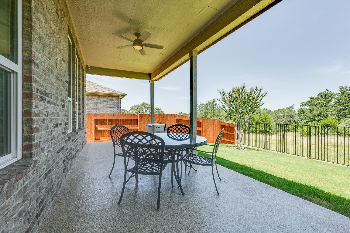 616 Climbing Rock Loop Dripping Springs, TX 78620 - Photo 22 of 35 Fenced backyard featuring a patio area, ceiling fan, and outdoor dining space