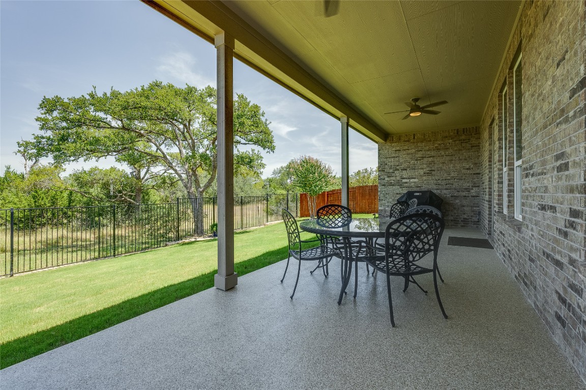 616 Climbing Rock Loop Dripping Springs, TX 78620 - Photo 23 of 35 Fenced backyard with ceiling fan, a patio, and outdoor dining space