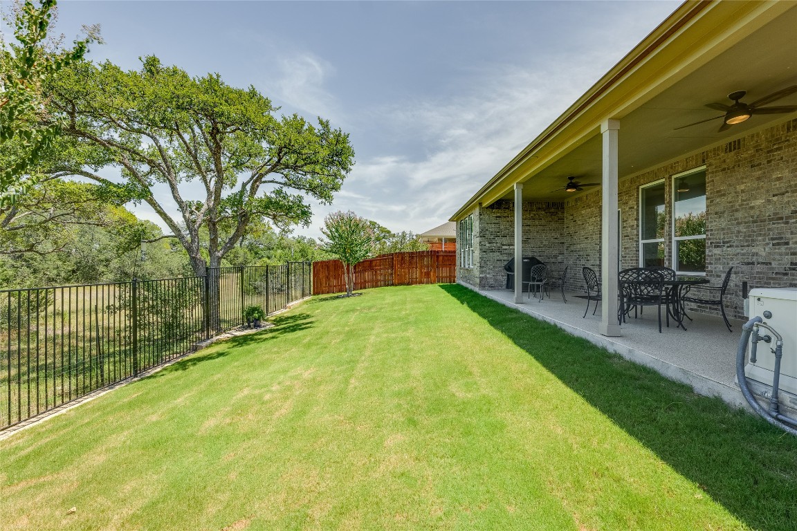 616 Climbing Rock Loop Dripping Springs, TX 78620 - Photo 24 of 35 Fenced backyard with ceiling fan and a patio