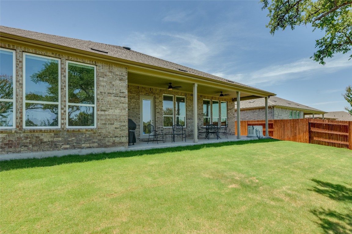 616 Climbing Rock Loop Dripping Springs, TX 78620 - Photo 26 of 35 Rear view of house with brick siding, ceiling fan, a patio area, and a shingled roof