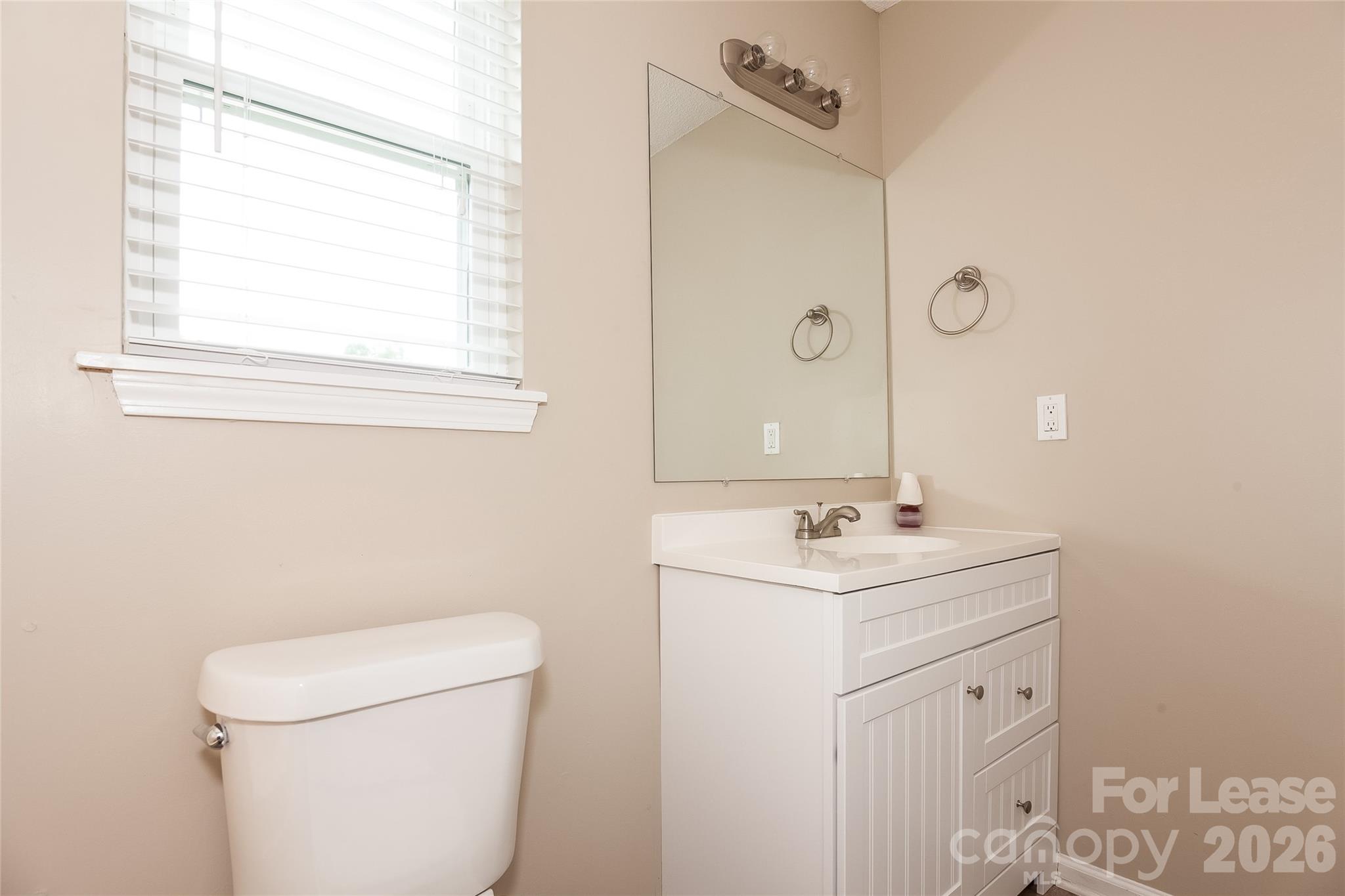 8625 Flowers Court Charlotte, NC 28215 - Photo 14 of 16 a bathroom with a sink toilet and mirror