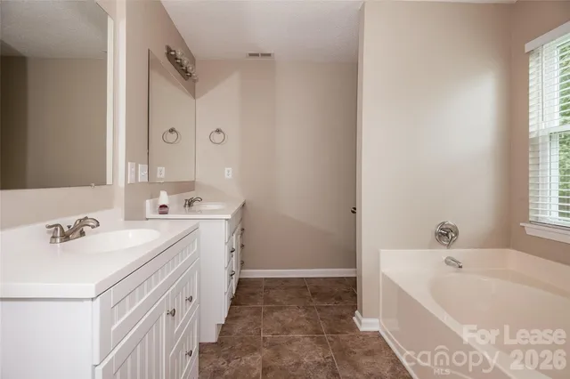 a bathroom with a tub sink and mirror