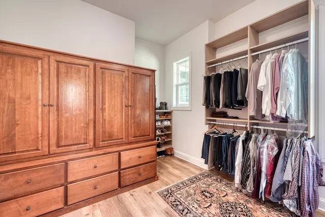 a view of walk in closet with clothes