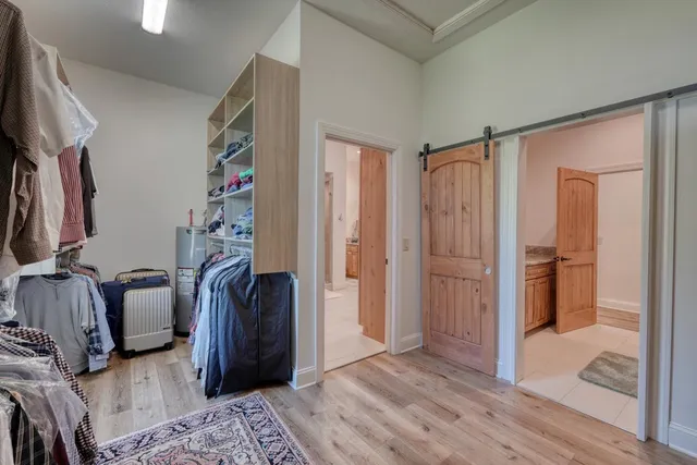 a view of walk in closet with clothes and shoes