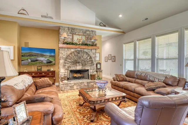 a living room with furniture fireplace and a large window