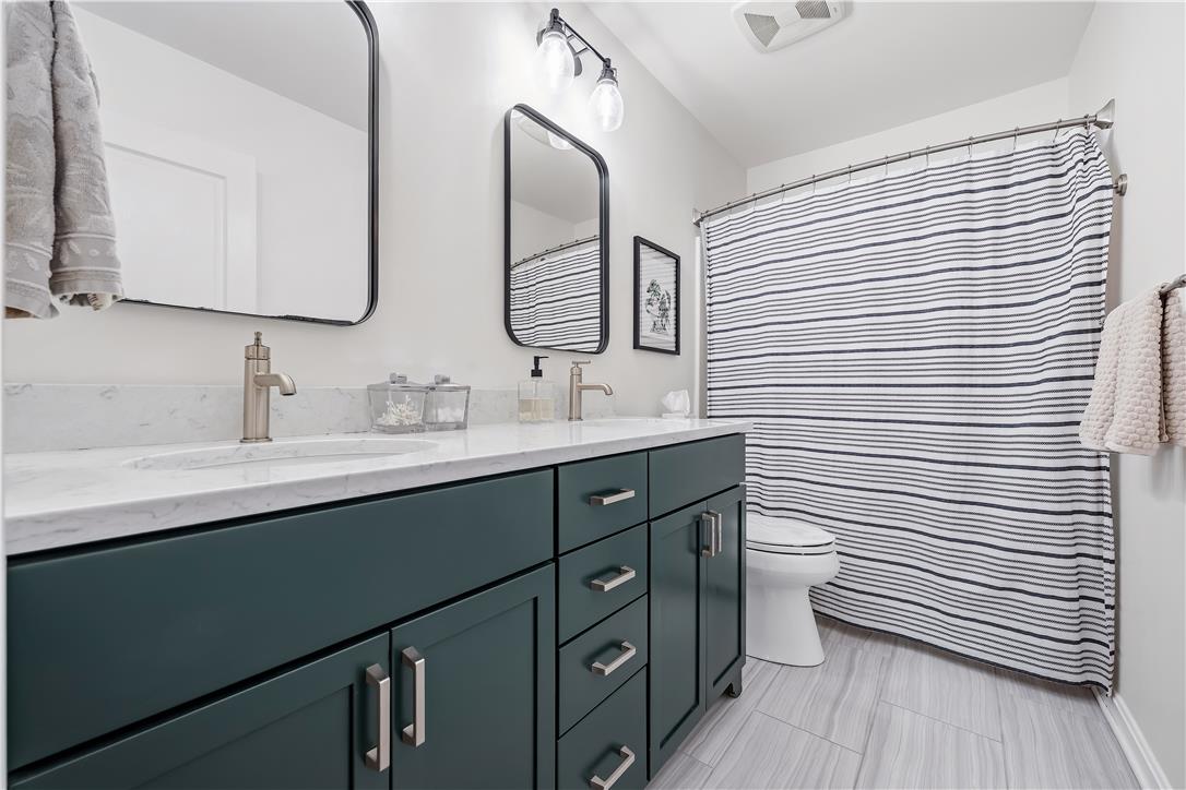 9031 Pathfinder Road Breinigsville, PA 18031 - Photo 42 of 63 Dual vanities with stone counters and modern fixtures anchor this inviting bathroom.