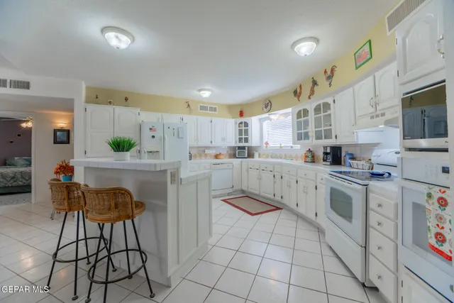 a kitchen with cabinets and chairs