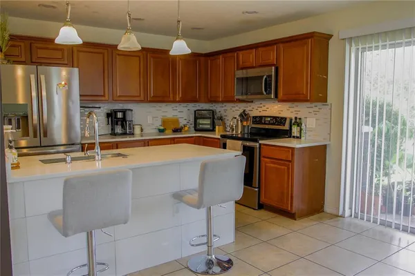 a kitchen with stainless steel appliances granite countertop a sink a stove a microwave a refrigerator and cabinets
