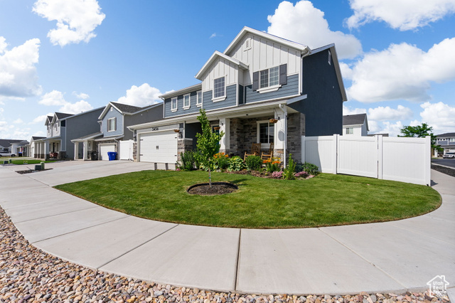 3456 South Linden Way Syracuse, UT 84075 - Photo 47 of 50 View of front of home with board and batten siding, driveway, a porch, stone siding, and a residential view