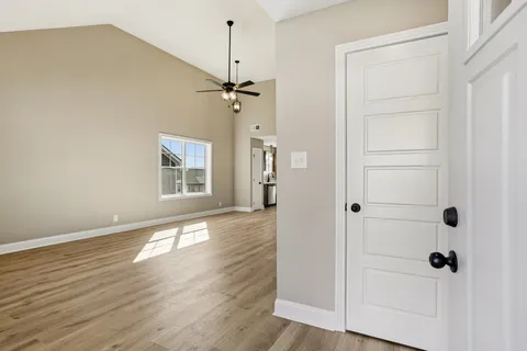 a view of a hallway with wooden floor and closet