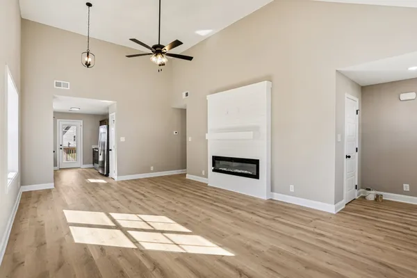 a view of an empty room with a window and a ceiling fan