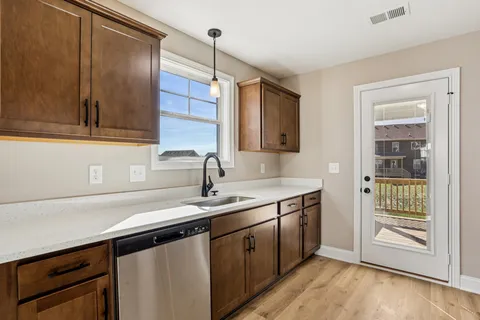 a kitchen with a sink cabinets and wooden floor