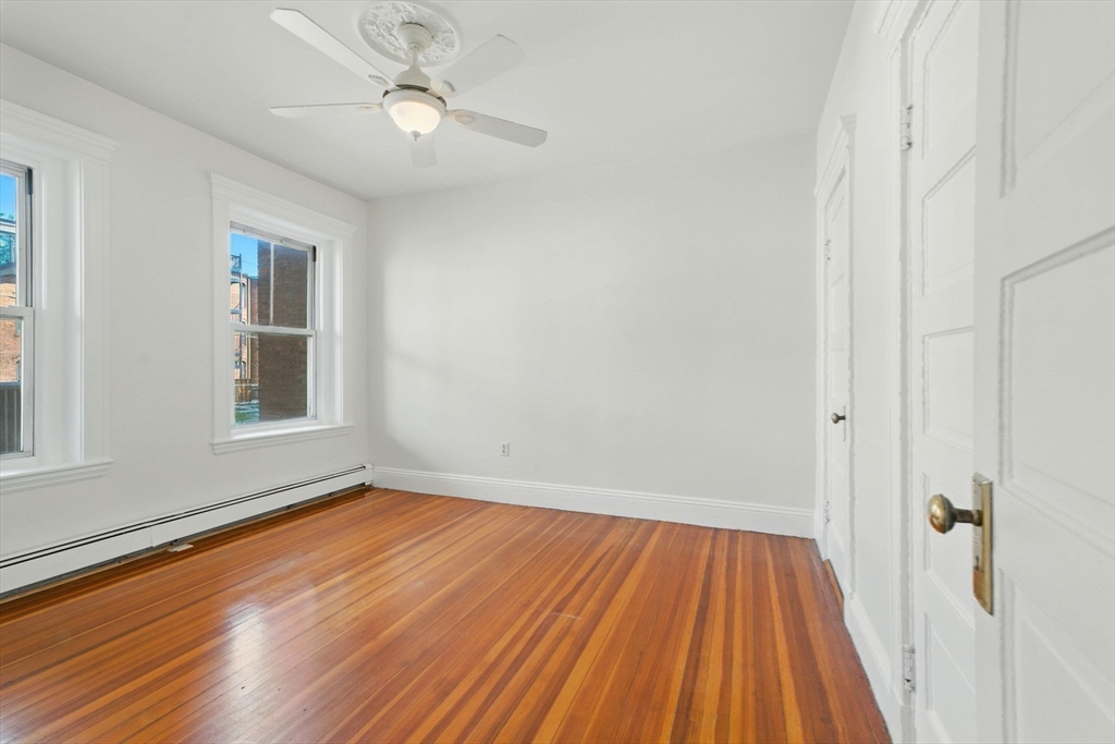 17 Strathmore Road, Unit 2 Brookline, MA 02445 - Photo 26 of 32 a view of an empty room with wooden floor and a window