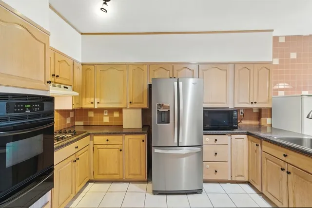 a kitchen with stainless steel appliances granite countertop a refrigerator and a stove