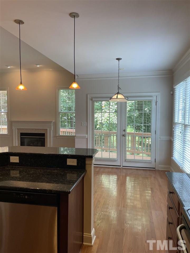 7370 Fontana Ridge Lane Raleigh, NC 27613 - Photo 12 of 27 a kitchen with kitchen island granite countertop a stove a sink a window and dining table