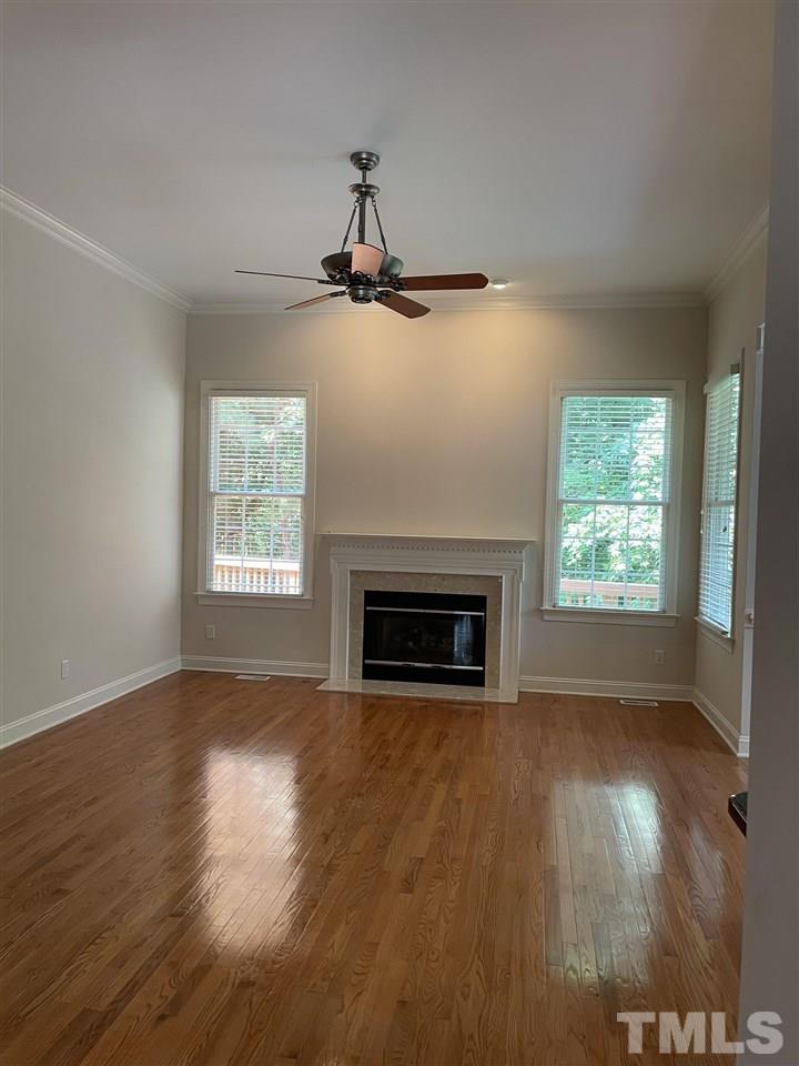 7370 Fontana Ridge Lane Raleigh, NC 27613 - Photo 8 of 27 a view of empty room with wooden floor and fireplace