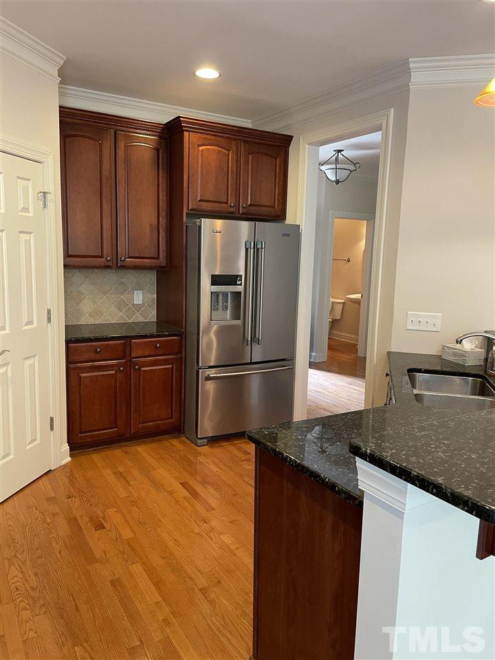 7370 Fontana Ridge Lane Raleigh, NC 27613 - Photo 10 of 27 a kitchen with stainless steel appliances granite countertop a refrigerator a sink a stove with wooden cabinets and wooden floor