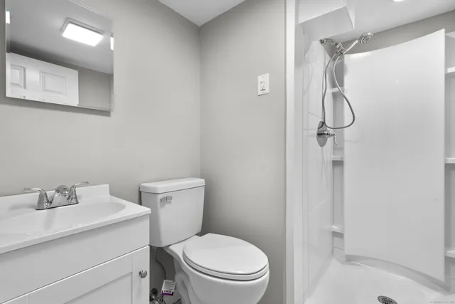 a bathroom with a toilet a sink and mirror