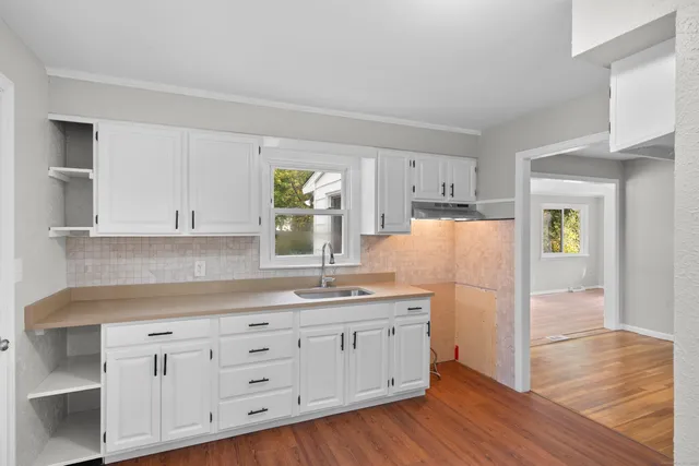 a kitchen with granite countertop a sink and a stove top oven