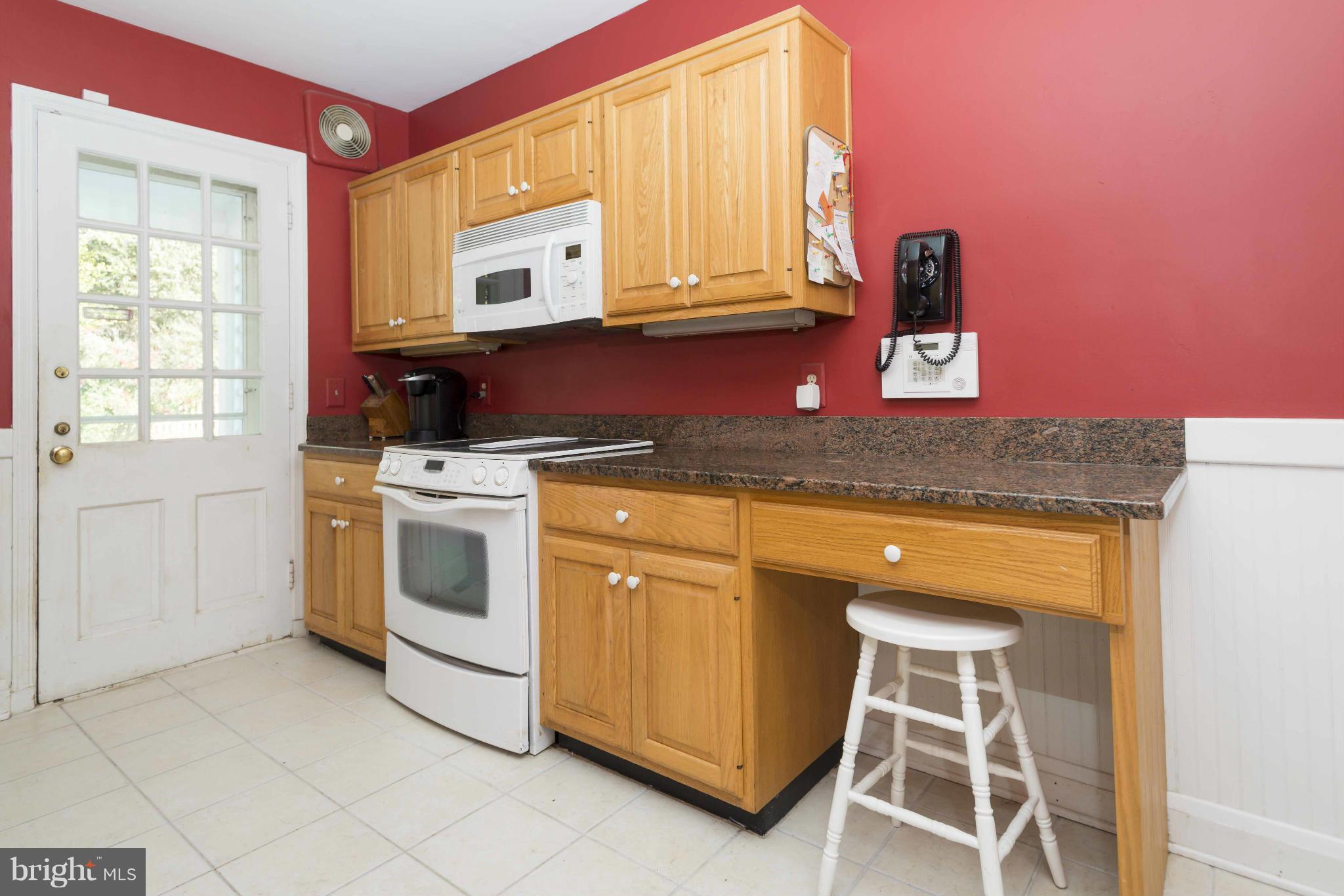 208 Taplow Road Baltimore, MD 21212 - Photo 8 of 30 a kitchen with stainless steel appliances granite countertop a stove a sink and a microwave