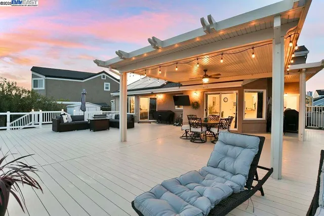 a view of a patio with dining table and chairs with a barbeque grill and a fireplace