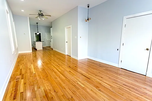 a view of a room with wooden floor and a bathroom