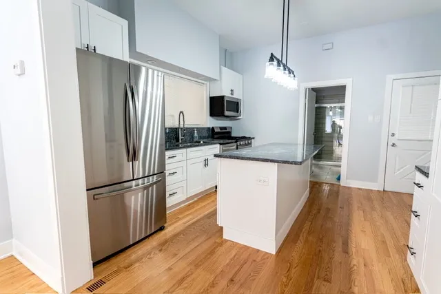 a kitchen with stainless steel appliances granite countertop a refrigerator a stove and a sink