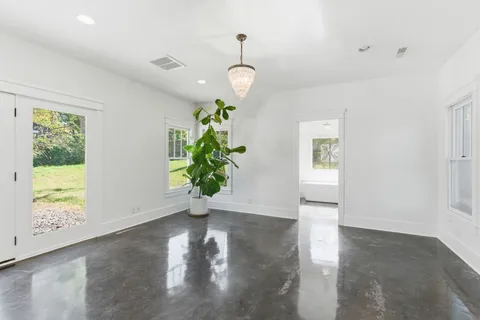 an empty room with a window and wooden floor